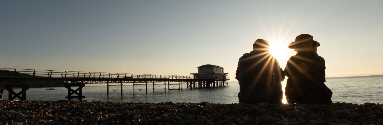 Couple enjoying the sunset whilst sat at Totland Bay